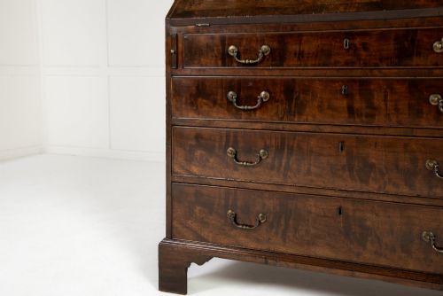 fig 1. An 18th-century Georgian mahogany bureau bookcase featuring a twin-door upper cabinet with astragal glazing bars over a slant-front writing slope and four graduated drawers on bracket feet.