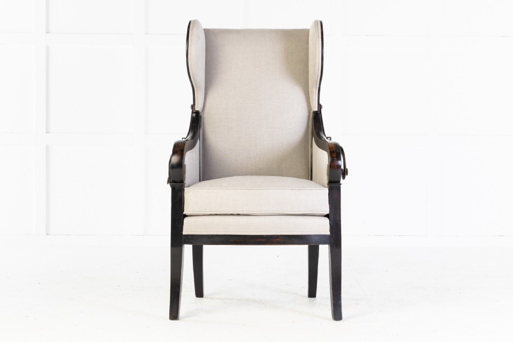 Early 19th-century French wingback armchair featuring an ebonised wooden frame, iron ratchet reclining mechanism, and light grey linen upholstery. View II