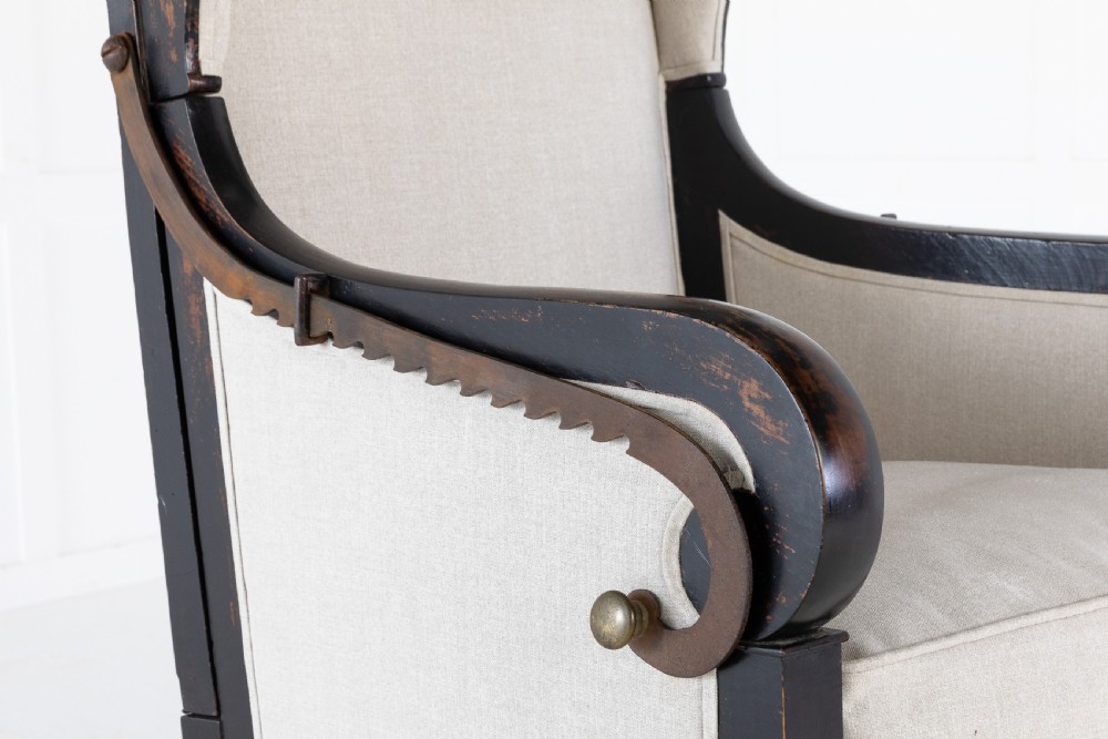 Early 19th-century French wingback armchair featuring an ebonised wooden frame, iron ratchet reclining mechanism, and light grey linen upholstery. View III