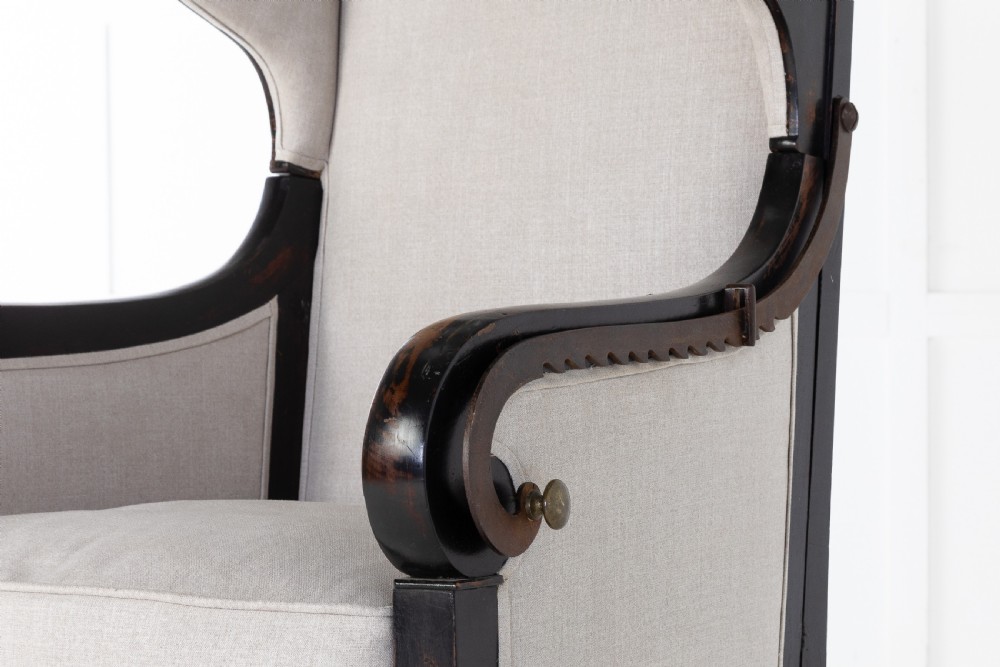 Early 19th-century French wingback armchair featuring an ebonised wooden frame, iron ratchet reclining mechanism, and light grey linen upholstery. View IV
