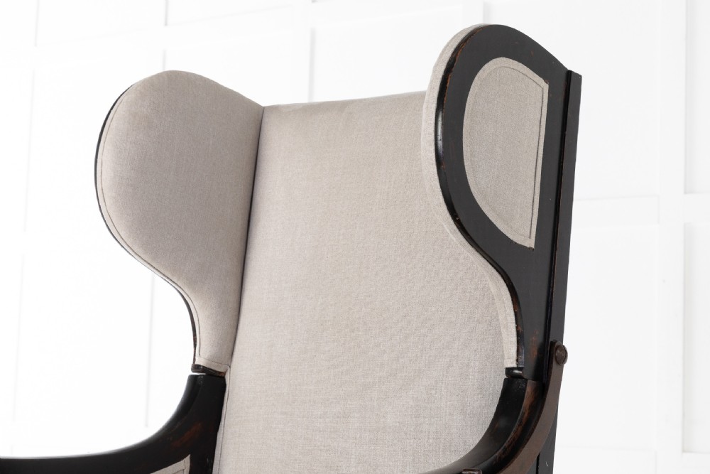 Early 19th-century French wingback armchair featuring an ebonised wooden frame, iron ratchet reclining mechanism, and light grey linen upholstery. View V