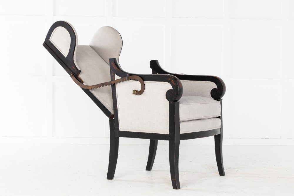 Early 19th-century French wingback armchair featuring an ebonised wooden frame, iron ratchet reclining mechanism, and light grey linen upholstery. View VII
