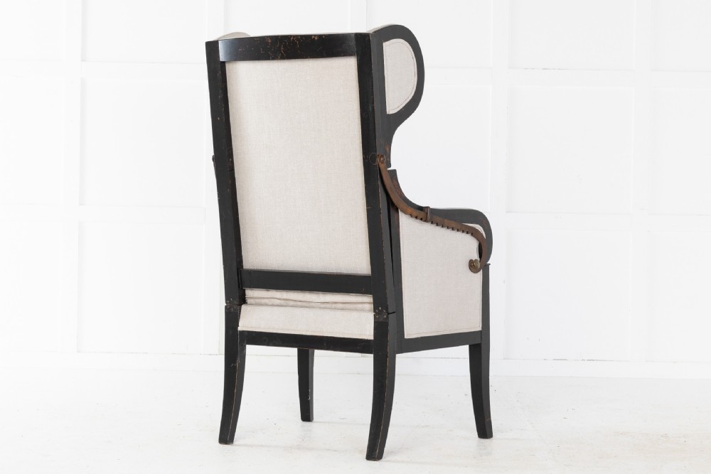 Early 19th-century French wingback armchair featuring an ebonised wooden frame, iron ratchet reclining mechanism, and light grey linen upholstery. View VIII