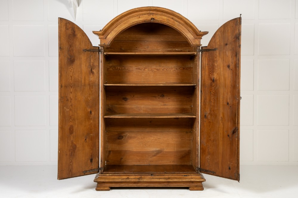 An eighteenth-century Italian pine armoire featuring an arched pediment, double doors with raised moulded panels, and wrought iron lock hardware. View II