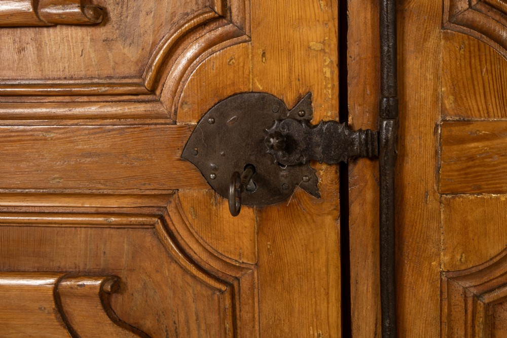An eighteenth-century Italian pine armoire featuring an arched pediment, double doors with raised moulded panels, and wrought iron lock hardware. View VI