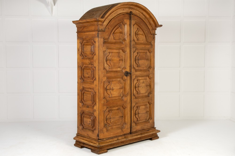 An eighteenth-century Italian pine armoire featuring an arched pediment, double doors with raised moulded panels, and wrought iron lock hardware. View VIII