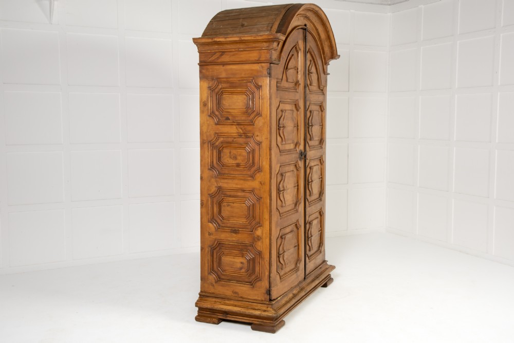 An eighteenth-century Italian pine armoire featuring an arched pediment, double doors with raised moulded panels, and wrought iron lock hardware. View IX