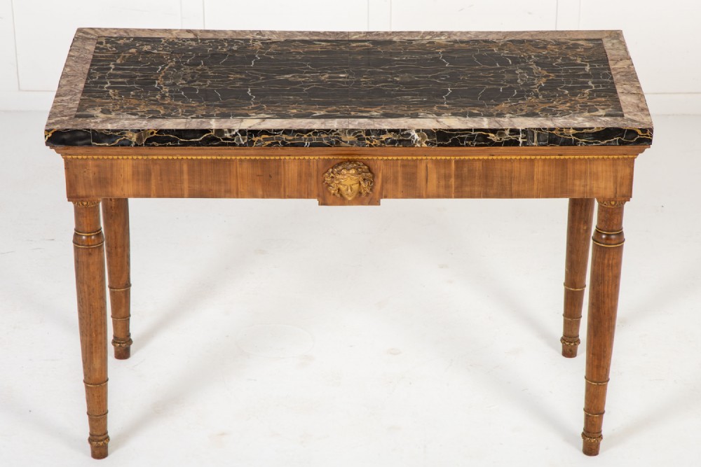 A 19th-century Italian walnut console table with a black marble top, gilt mask motif, and tapered legs. View II