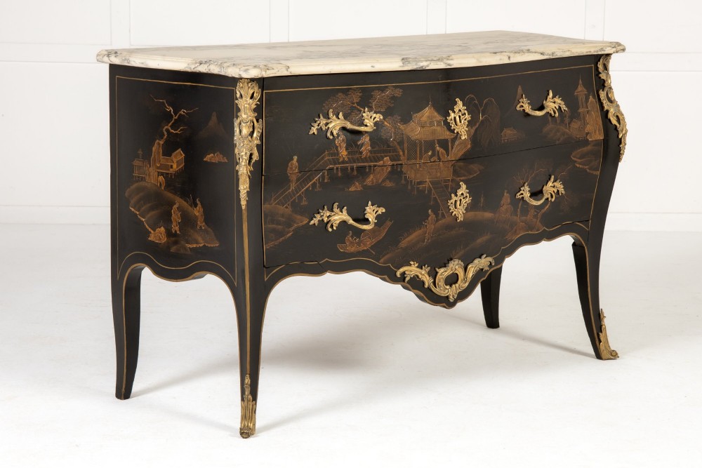 A French Louis XV style bombe commode featuring black japanned lacquer with detailed gold Chinoiserie landscapes, a shaped marble top, and gilt bronze mounts.