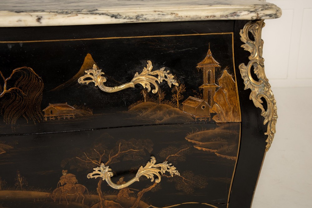 A French Louis XV style bombe commode featuring black japanned lacquer with detailed gold Chinoiserie landscapes, a shaped marble top, and gilt bronze mounts. View II