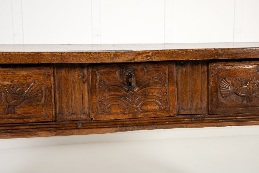 A 17th-century Spanish walnut side table featuring three carved drawer fronts, turned legs, and a low stretcher base. View IV