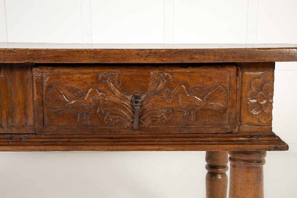 A 17th-century Spanish walnut side table featuring three carved drawer fronts, turned legs, and a low stretcher base. View V