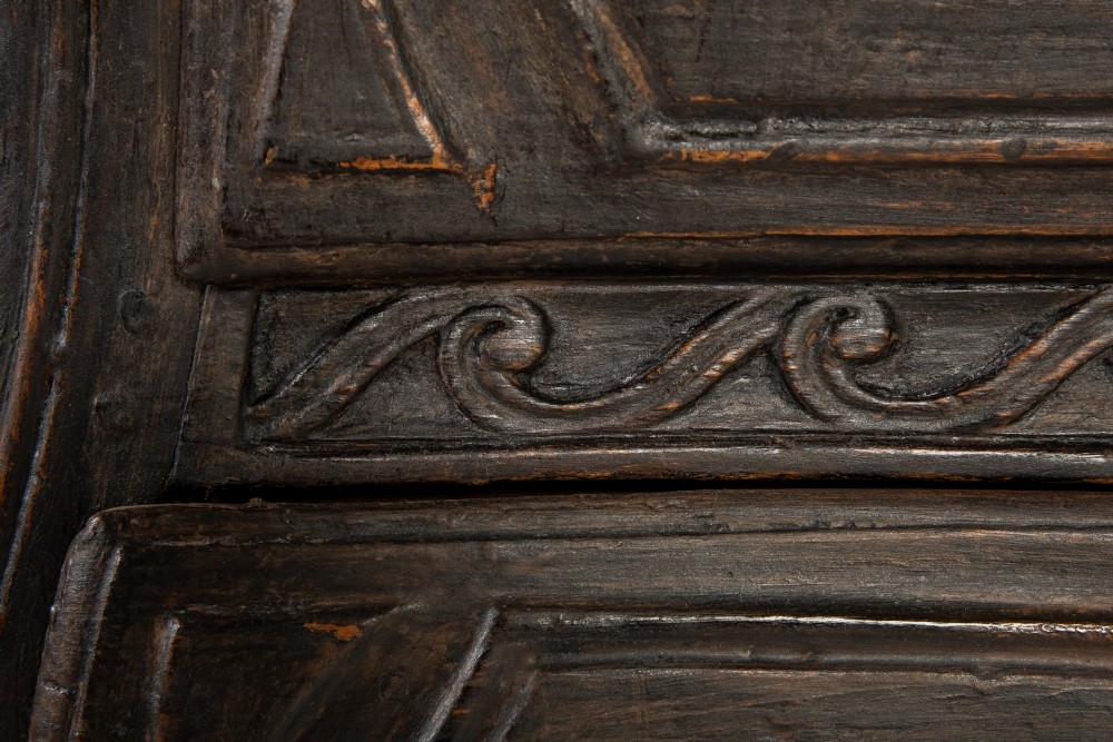 An 18th-century ebonised French bombe commode featuring three drawers, carved panels, a grey marble top, and brass keyholes. View VI