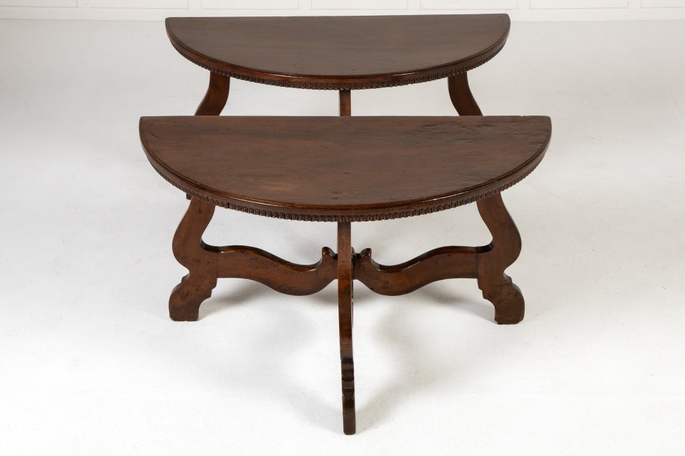 A pair of 18th-century Italian walnut demi-lune console tables with carved dentil edges, shaped legs, and central stretchers. View II