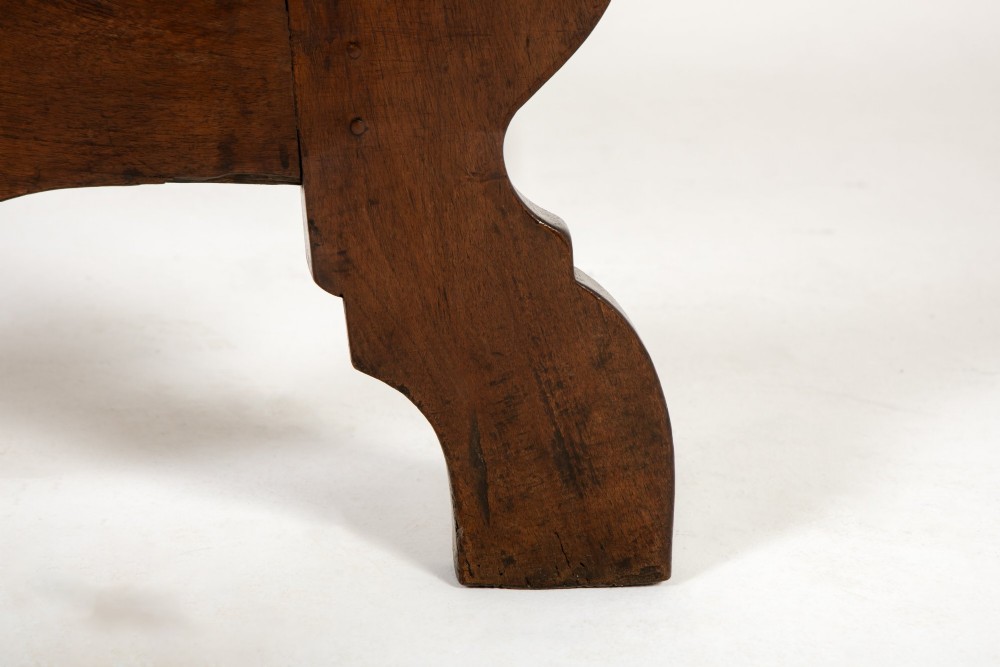 A pair of 18th-century Italian walnut demi-lune console tables with carved dentil edges, shaped legs, and central stretchers. View IX