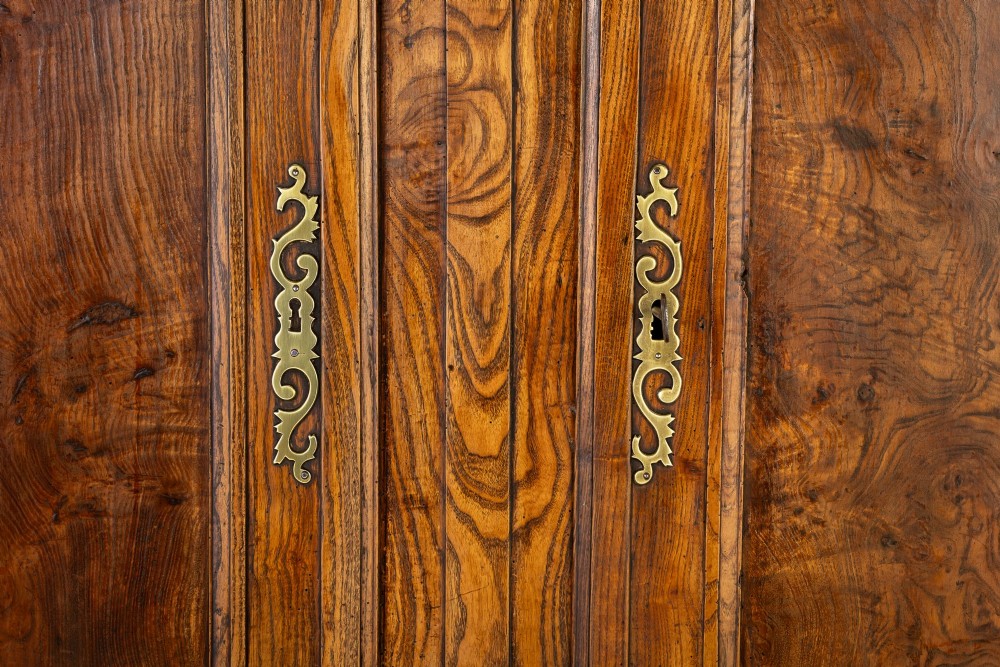 An 18th-century French ash buffet deux corps featuring two upper panelled doors, two lower doors, and carved apron details. View VII