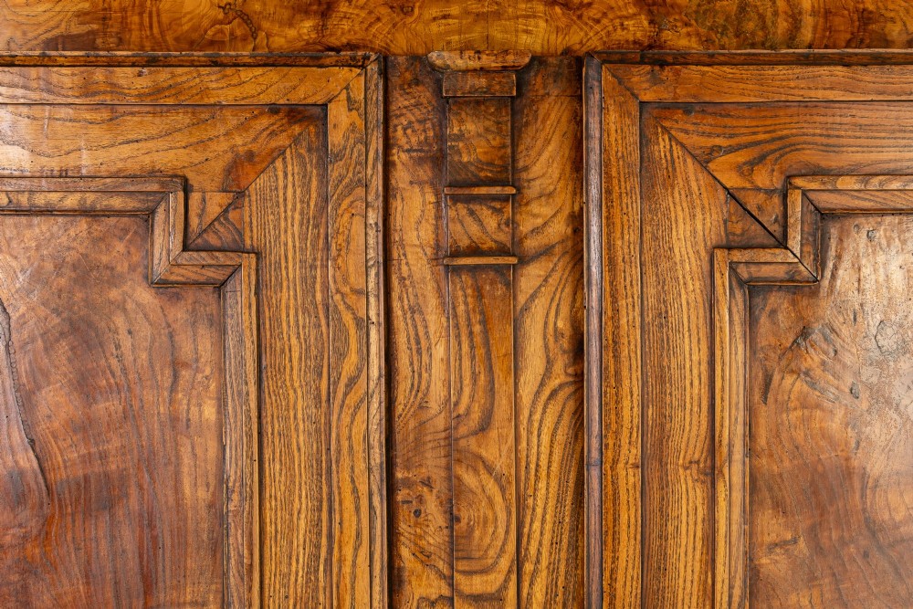 An 18th-century French ash buffet deux corps featuring two upper panelled doors, two lower doors, and carved apron details. View IX