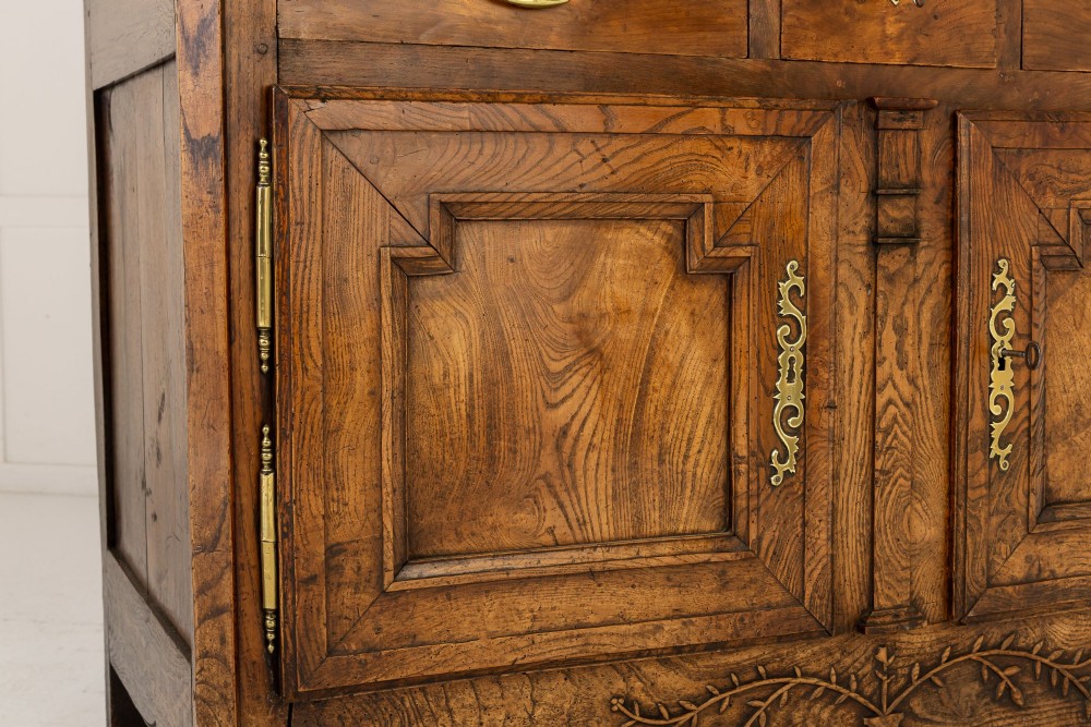 An 18th-century French ash buffet deux corps featuring two upper panelled doors, two lower doors, and carved apron details. View XII
