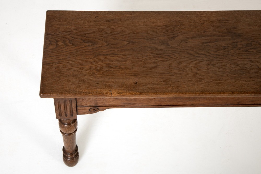 A long 19th-century dark oak bench featuring a rectangular plank seat supported by turned legs with fluted frieze details. View IV