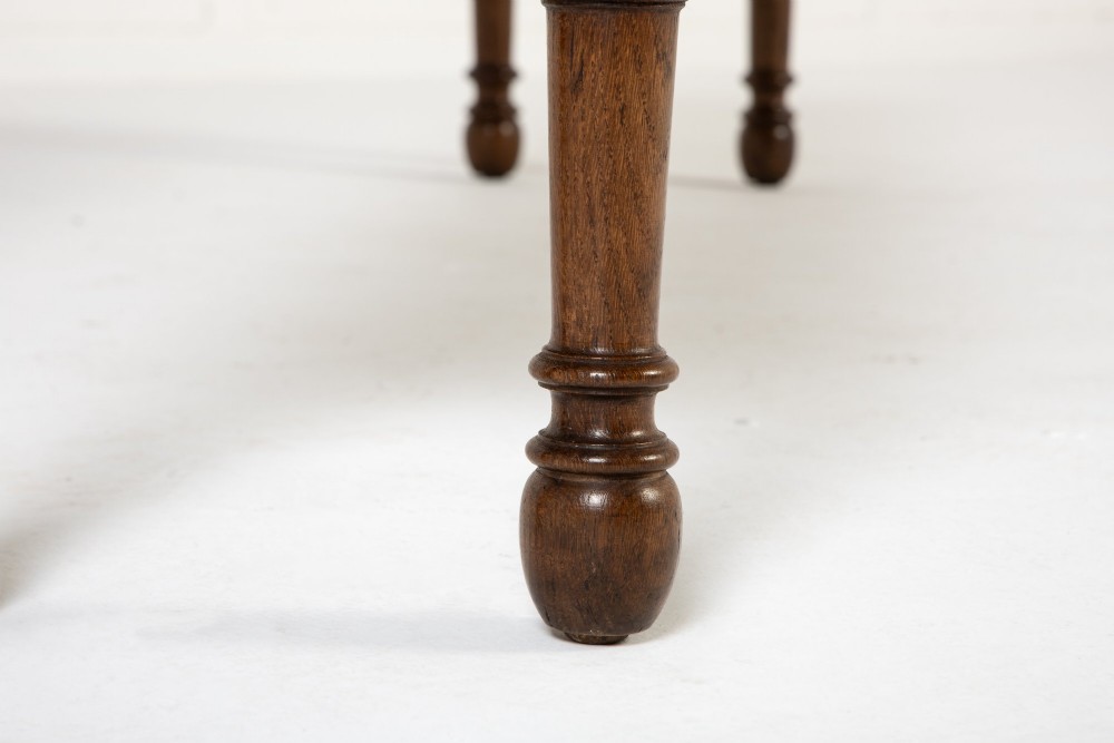 A long 19th-century dark oak bench featuring a rectangular plank seat supported by turned legs with fluted frieze details. View VI