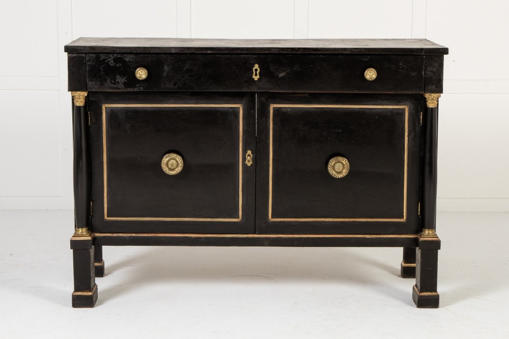 A pair of matching 18th-century Italian ebonised side cabinets featuring gilt metal mounts, fluted corner columns, single top drawers, and double panelled doors. View II