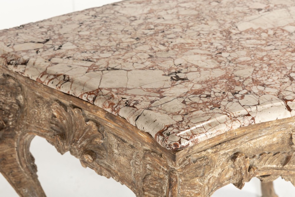An 18th-century Italian Rococo silver-gilt console table featuring carved leaf motifs, cabriole legs, and a rectangular pink marble top. View IV