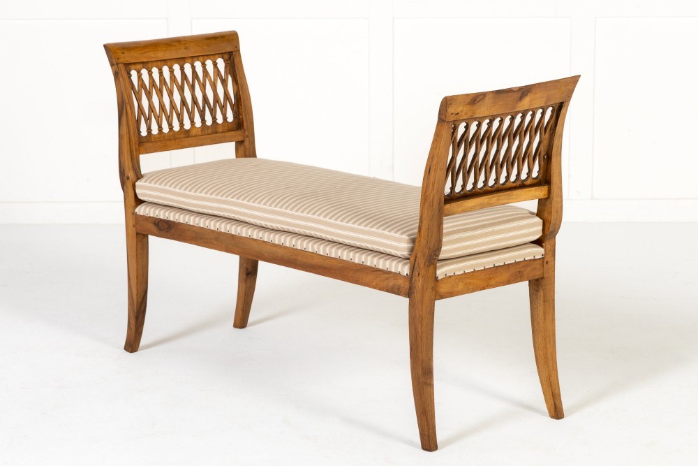 A pair of 19th-century French walnut window seats with carved lattice ends and striped upholstered cushions. View V