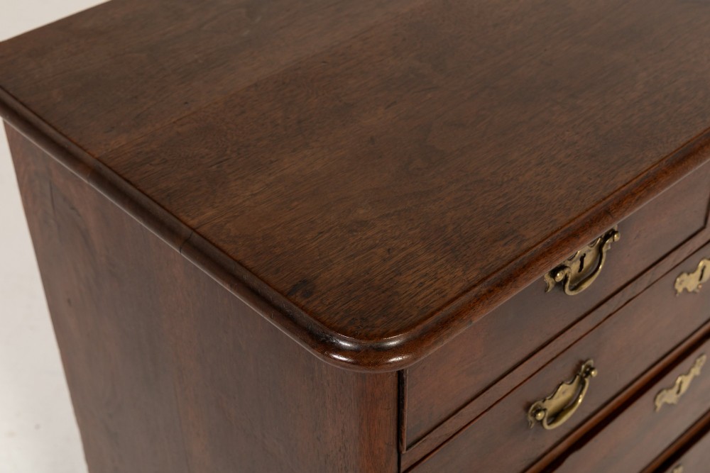 An 18th-century English walnut chest of drawers featuring two short drawers over three long drawers with brass hardware and bracket feet. View III