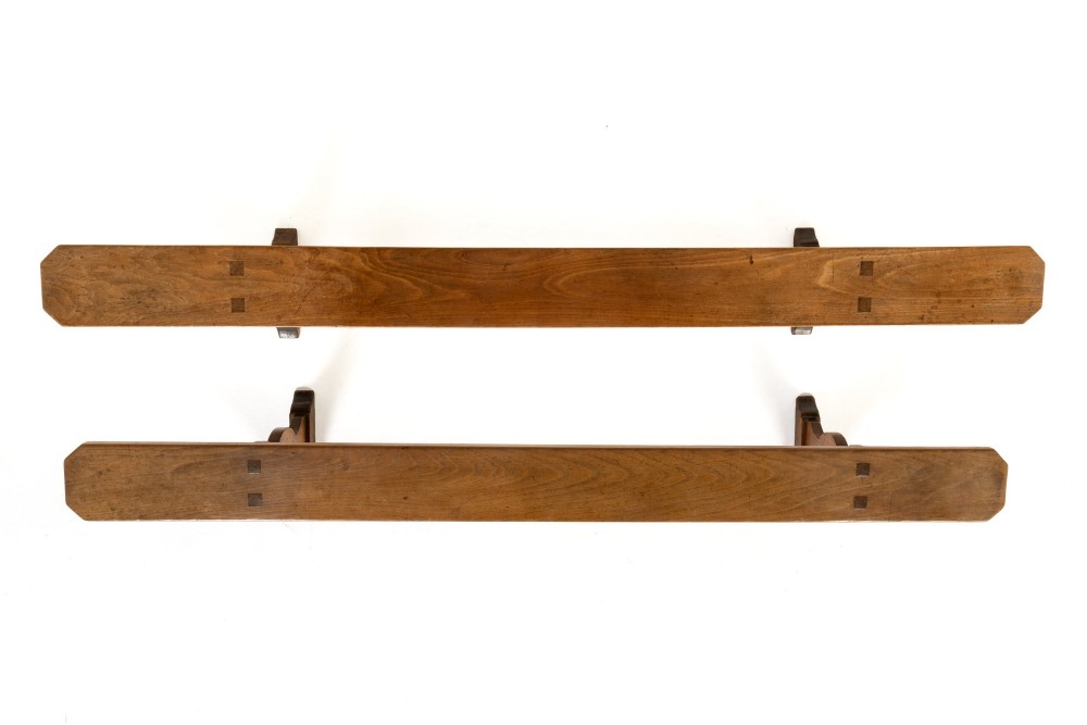 A pair of 19th-century French backless wooden hall benches featuring shaped trestle supports and visible joinery. View II