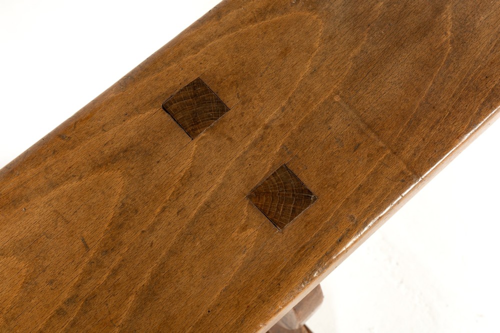 A pair of 19th-century French backless wooden hall benches featuring shaped trestle supports and visible joinery. View VI