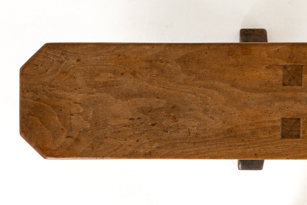 A pair of 19th-century French backless wooden hall benches featuring shaped trestle supports and visible joinery. View VIII