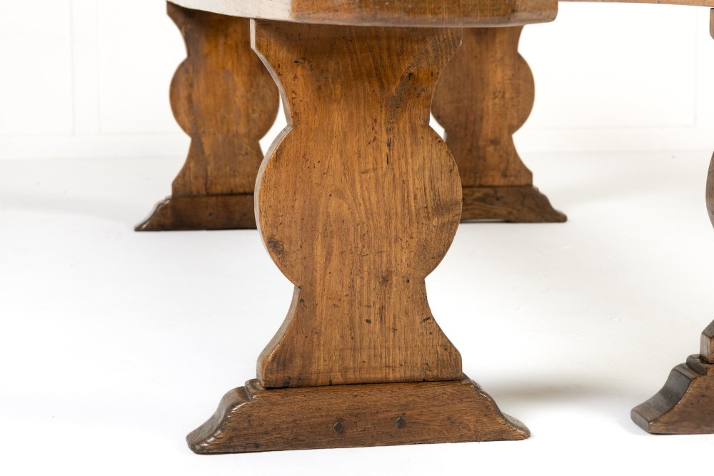 A pair of 19th-century French backless wooden hall benches featuring shaped trestle supports and visible joinery. View X