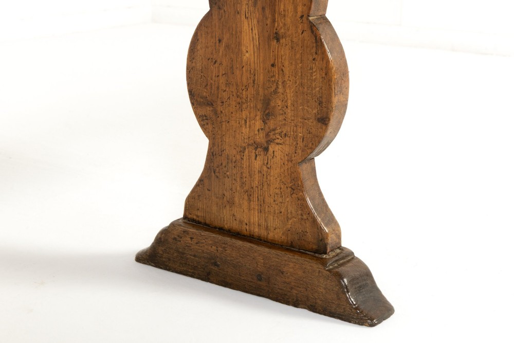 A pair of 19th-century French backless wooden hall benches featuring shaped trestle supports and visible joinery. View XI