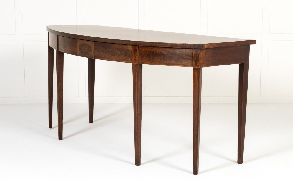 An 18th-century Georgian mahogany serving table featuring a curved apron with central oval inlay and four tapered square legs. View II