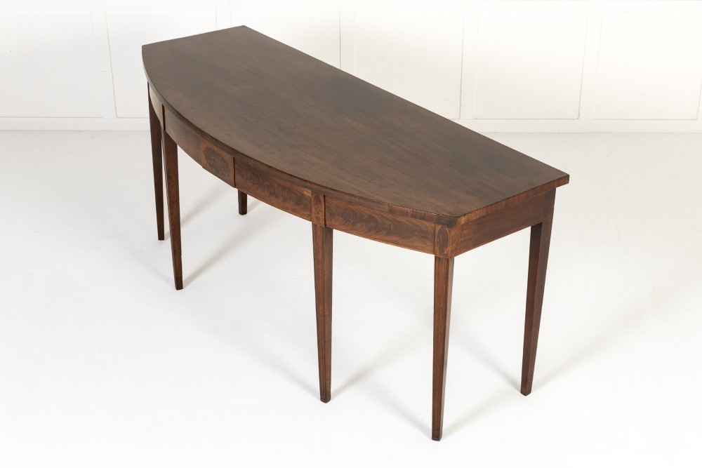 An 18th-century Georgian mahogany serving table featuring a curved apron with central oval inlay and four tapered square legs. View III