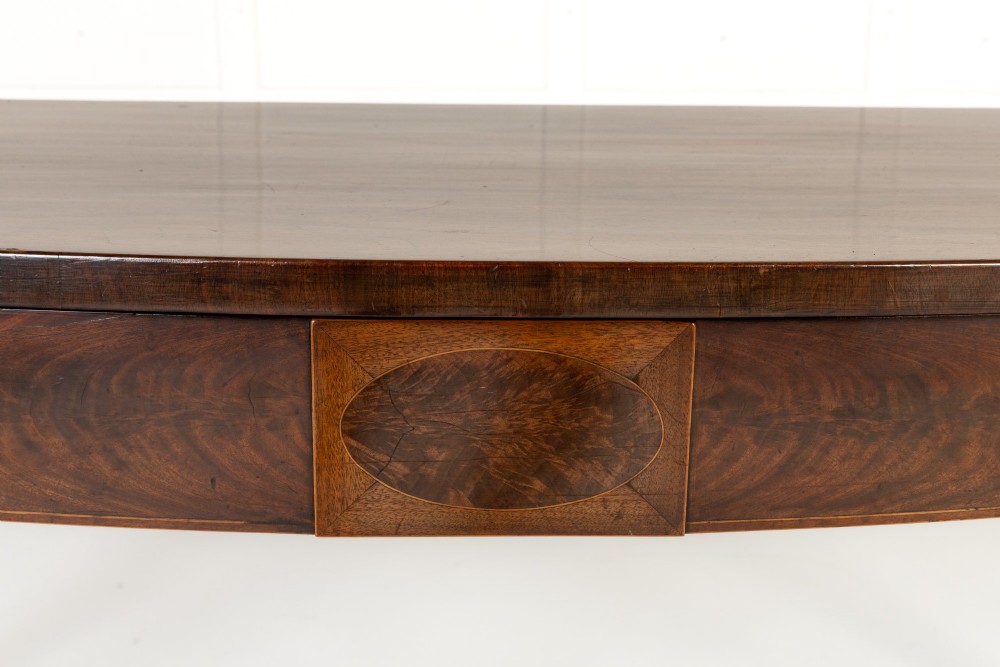 An 18th-century Georgian mahogany serving table featuring a curved apron with central oval inlay and four tapered square legs. View V