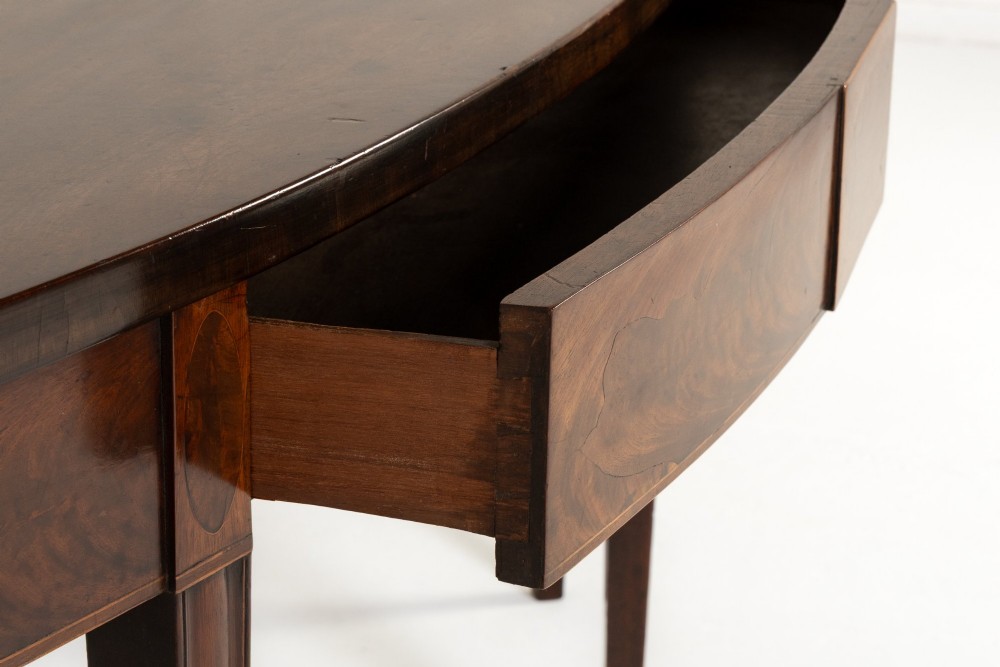 An 18th-century Georgian mahogany serving table featuring a curved apron with central oval inlay and four tapered square legs. View VII