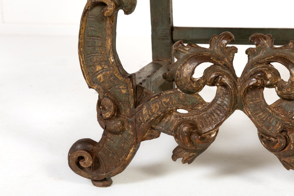 A pair of 17th-century Italian side chairs featuring tall backs upholstered in natural brown hessian, resting on elaborately carved scrollwork legs with a green painted finish. View IV