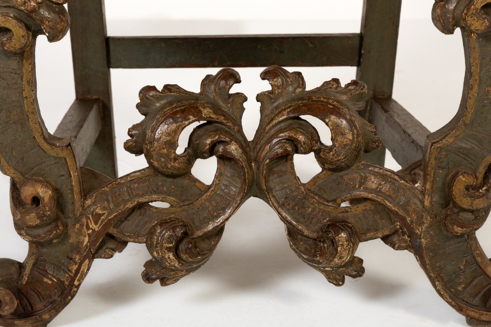 A high-backed 17th-century Italian Baroque armchair upholstered in beige hessian fabric with intricately carved wooden arms, legs, and a carved scroll front stretcher. View V