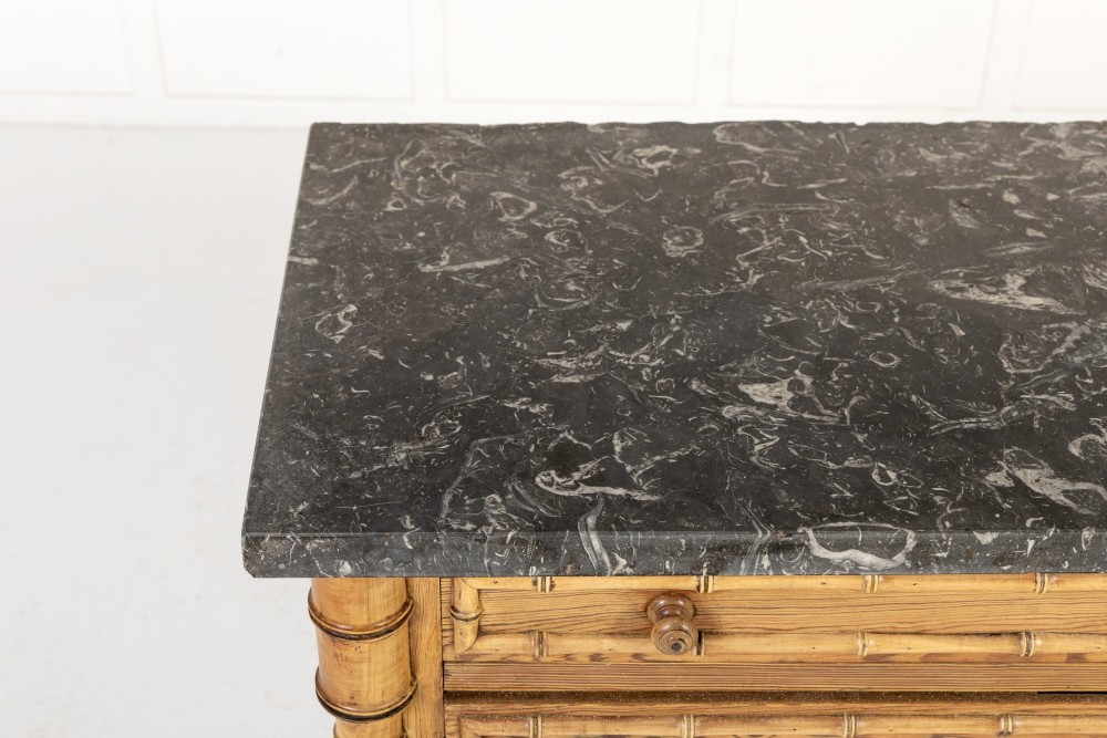 A 19th-century French pine chest of drawers featuring carved faux bamboo borders, four drawers with turned handles, and a grey marble top. View IV