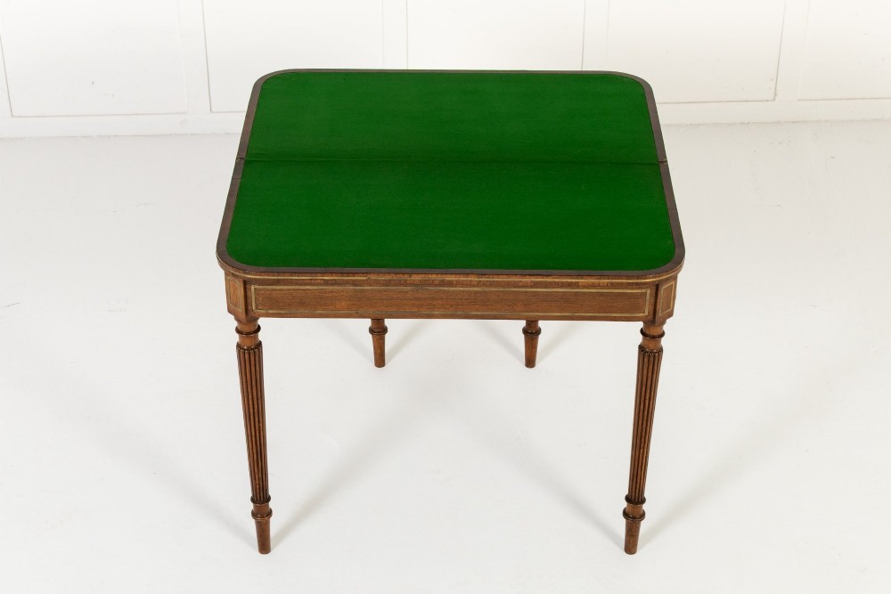 A pair of 19th-century English Regency rosewood foldover card tables with brass stringing inlay and fluted tapered legs. View VI