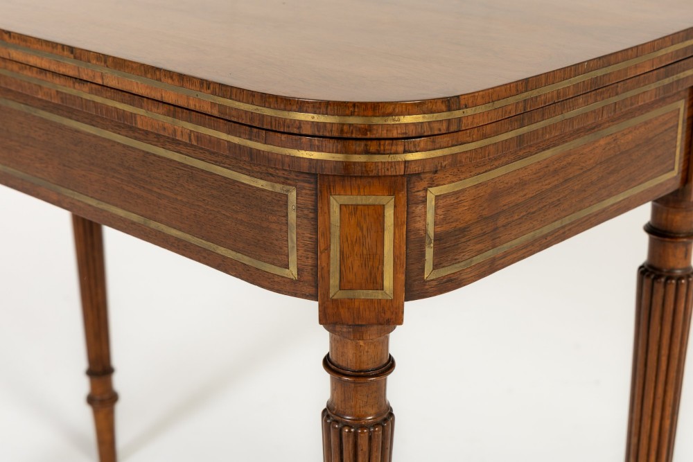 A pair of 19th-century English Regency rosewood foldover card tables with brass stringing inlay and fluted tapered legs. View X