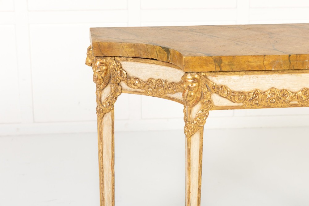 A 19th-century Italian Neoclassical console table featuring a painted cream frame, carved parcel gilt floral swags, tapered legs, and a marble top. View IV