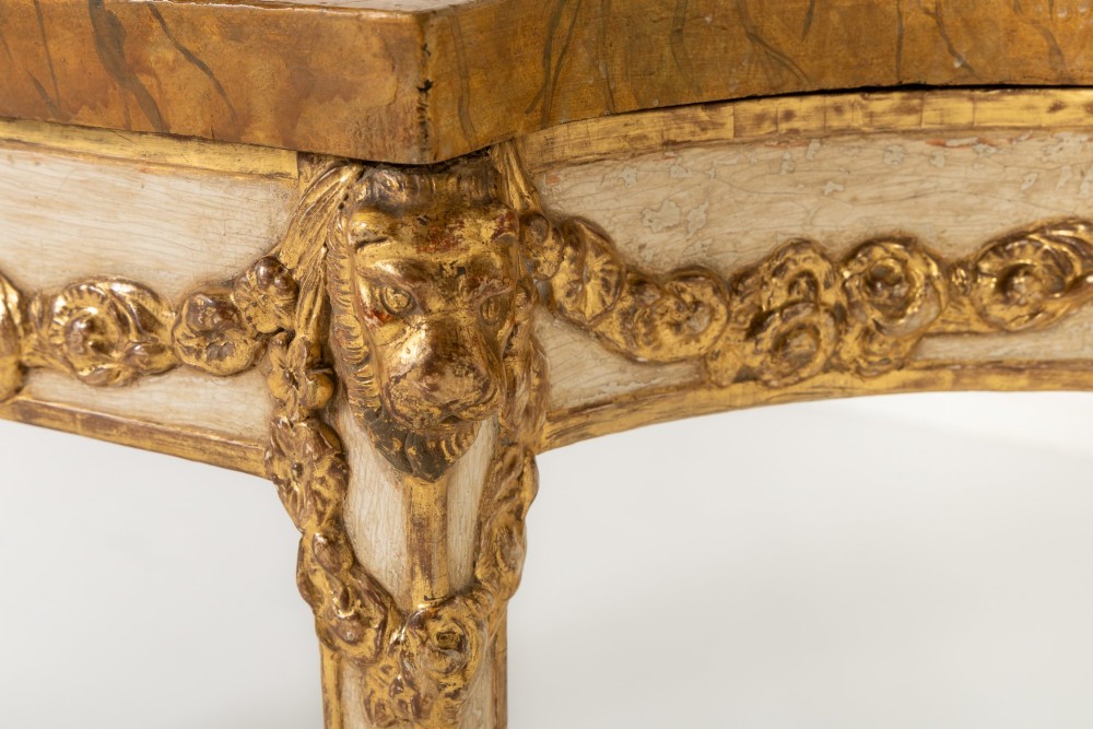 A 19th-century Italian Neoclassical console table featuring a painted cream frame, carved parcel gilt floral swags, tapered legs, and a marble top. View VI