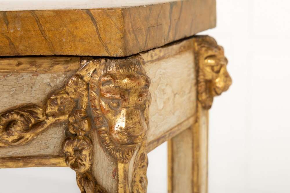 A 19th-century Italian Neoclassical console table featuring a painted cream frame, carved parcel gilt floral swags, tapered legs, and a marble top. View VII