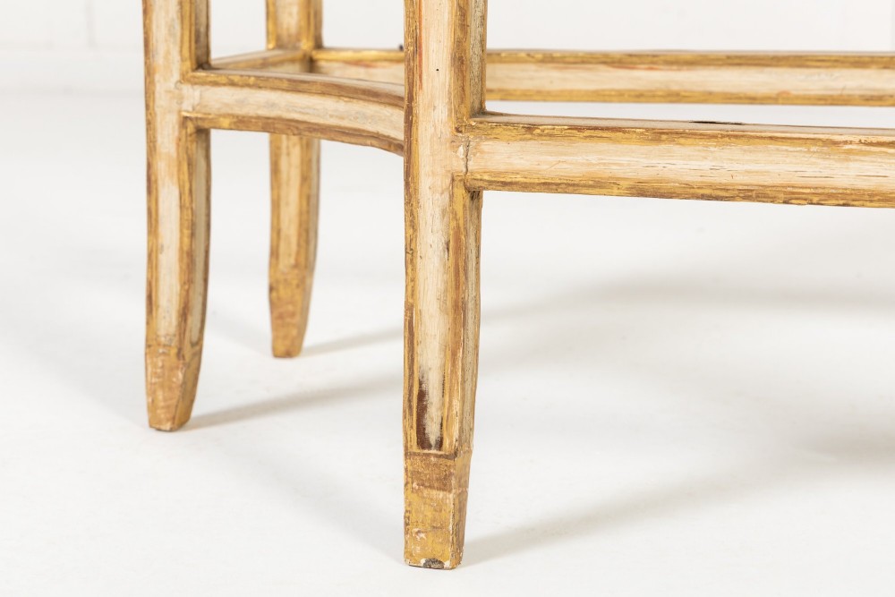 A 19th-century Italian Neoclassical console table featuring a painted cream frame, carved parcel gilt floral swags, tapered legs, and a marble top. View XI
