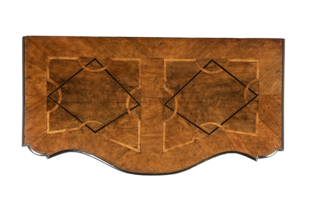 An 18th-century German walnut commode featuring three serpentine drawers with dark wood strapwork inlay and ornate brass escutcheons. View VII