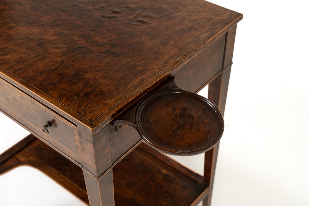 A small 19th-century burr yew wood writing table featuring a single drawer, two pull-out side slides, a lower undershelf, inlaid stringing, tapered legs, and brass casters. View II
