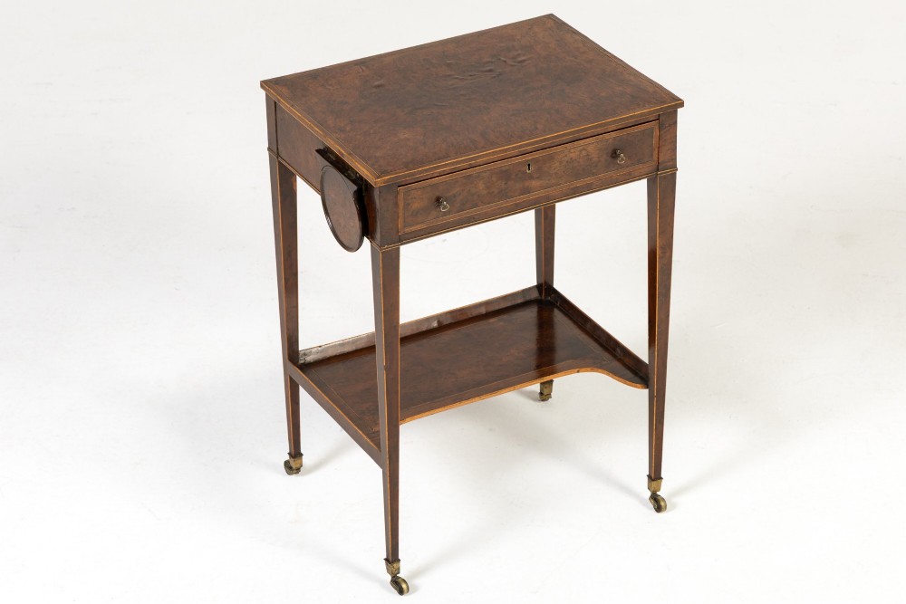 A small 19th-century burr yew wood writing table featuring a single drawer, two pull-out side slides, a lower undershelf, inlaid stringing, tapered legs, and brass casters. View III