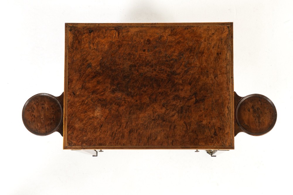 A small 19th-century burr yew wood writing table featuring a single drawer, two pull-out side slides, a lower undershelf, inlaid stringing, tapered legs, and brass casters. View V